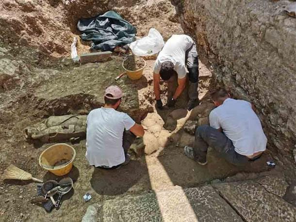 Archaeologists excavating giant urns
