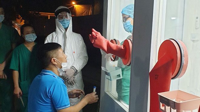 Healthcare workers at Tan Yen District testing the process in the heat-resistant sample collection booth.