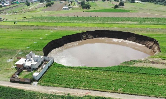As the sinkhole expands, large chunks of earth continuously break away from its edge.