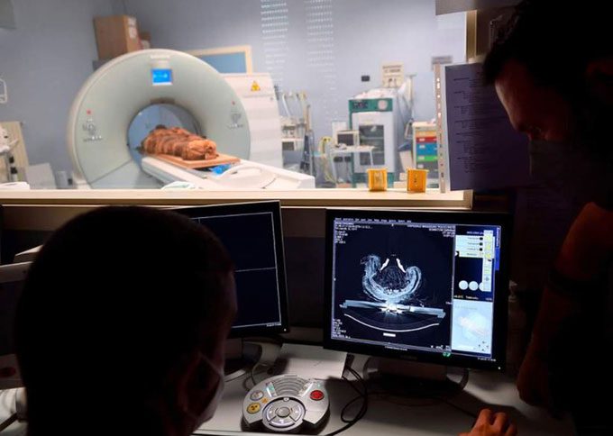 The research team viewing CT scan images of the mummy on a computer screen.