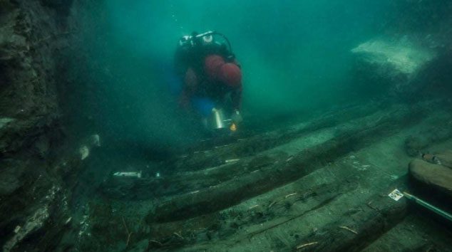 Divers near the mysterious ship next to the temple in the sunken city of Egypt.