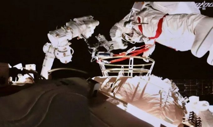 Astronaut Nie Haisheng exits the core module for the spacewalk