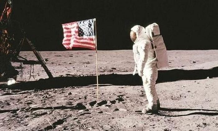 Astronaut Neil Armstrong plants the American flag on the Moon's surface.