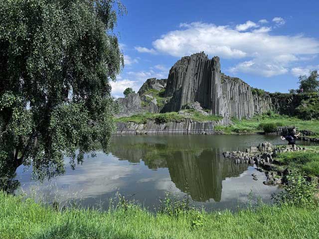 The rocks and tree shadows reflect a beautiful landscape in the lake