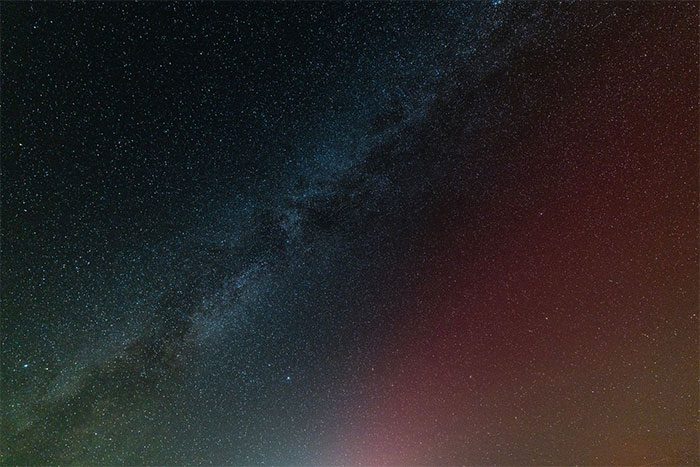 The Milky Way and aurora appearing together in the Sierra Nevada mountains, eastern California, USA.