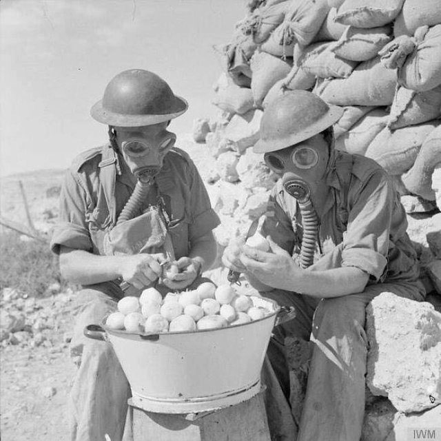 Soldiers wearing gas masks to peel onions, 1941