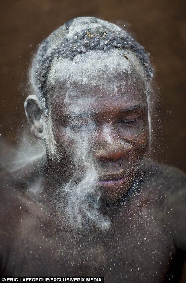 On the festival day, men cover their bodies with clay and ash before stepping out of their huts.