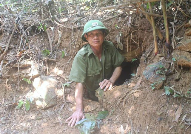 The entrance to the bunker is on the earthen wall, obscured by vegetation, allowing only one person to enter at a time.