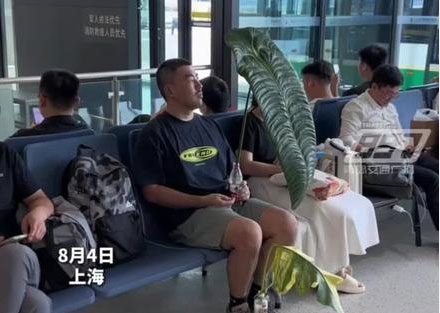 The young man clings to a giant leaf at Shanghai Airport, China.