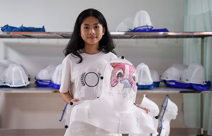 Thái Hòa (12 years old) holds her pink cat-shaped radiation mask.