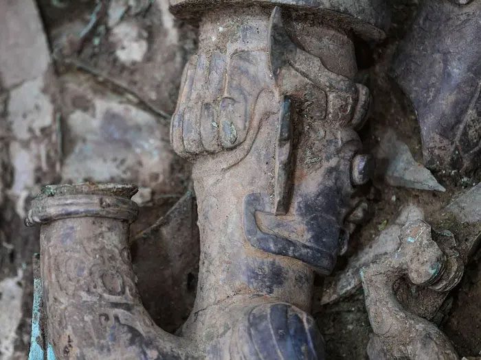 A bronze sculpture depicting a human head and snake body.