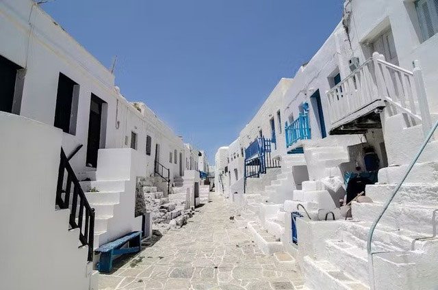 Whitewashed architecture with bright walls and roofs reflects sunlight.