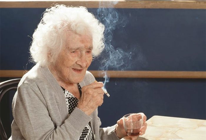 Jeanne Calment enjoying a cigarette and wine on her 117th birthday.