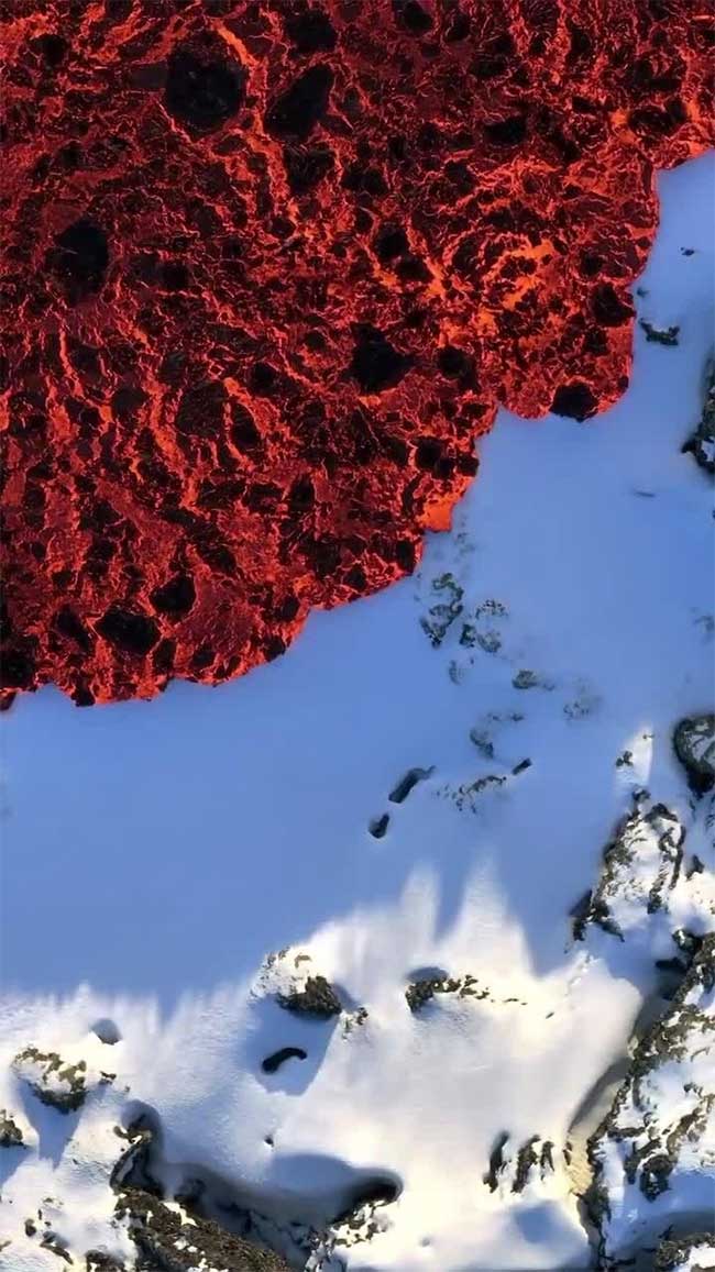 Lava from the Sundhnúkagígar volcano flowing over snow.