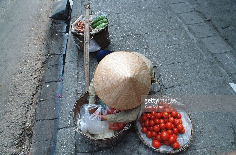 A woman selling fruits on the sidewalk.