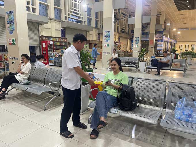 Passengers receiving food at Gia Lâm bus station.