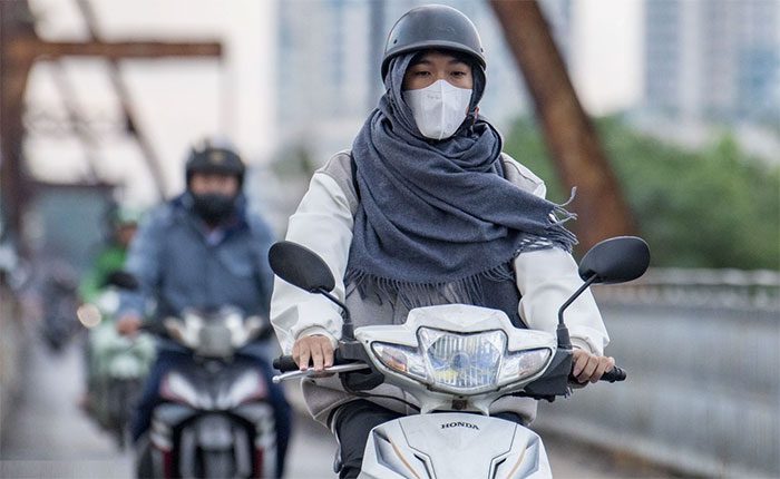 Hanoi residents wrap up for work in the cold wind