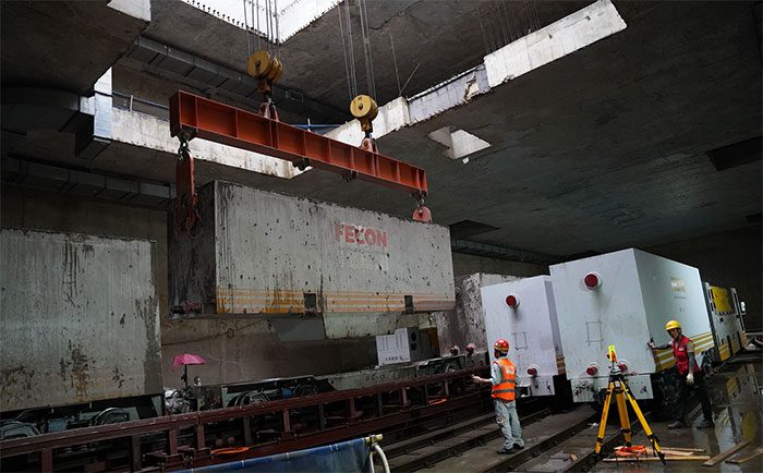 Waste containers are lifted to the surface by cranes and emptied into a storage tank.