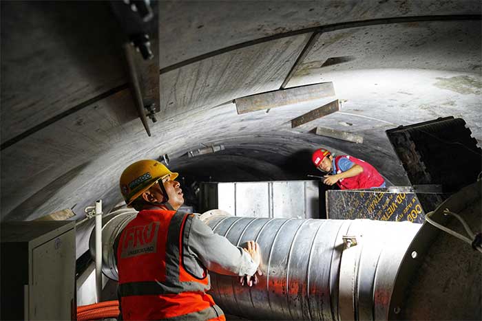 Workers check the ventilation system inside the tunnel.