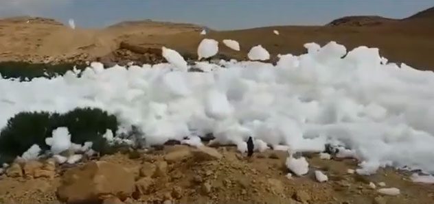 The video shows a large cloud descending to the ground on a hillside.