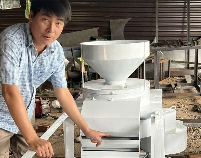 Nguyễn Trung Khánh next to his sacha inchi shell separation machine.