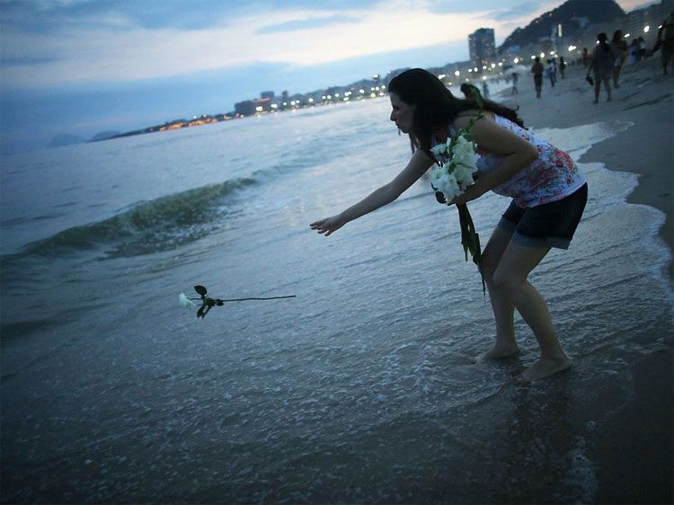 Throwing white flowers into the sea