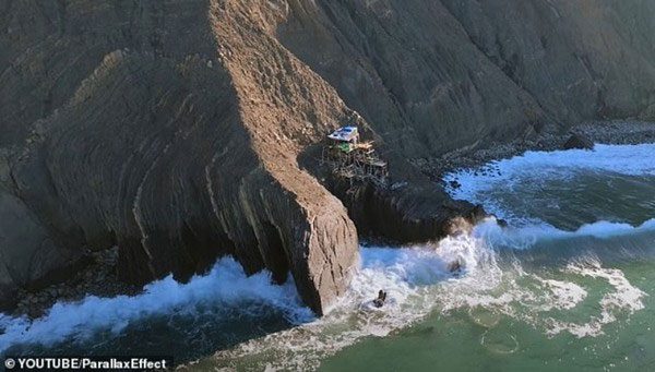 The house precariously sits on a steep and slippery cliff