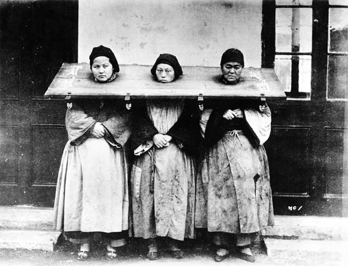 An image of three women wearing neck yokes.