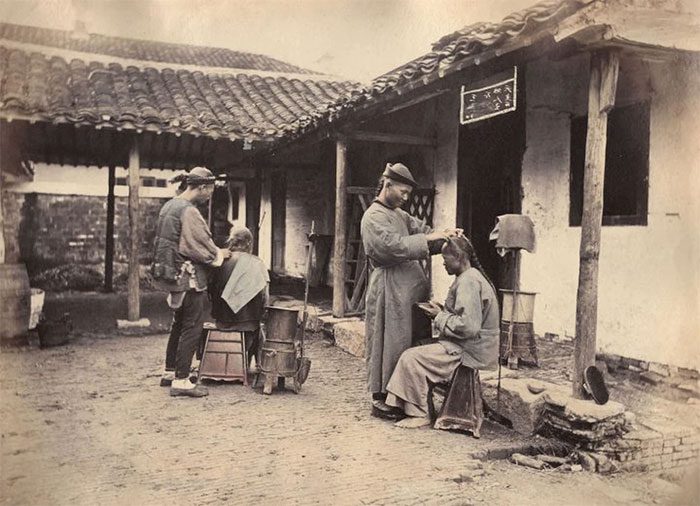 Barbers on a street corner in 1875.