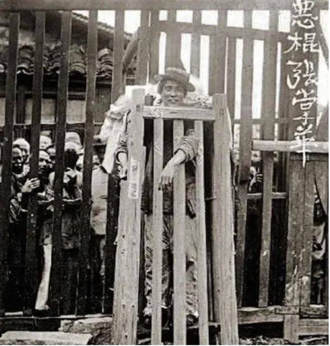 A prisoner paraded in a wooden cage for the crimes committed.