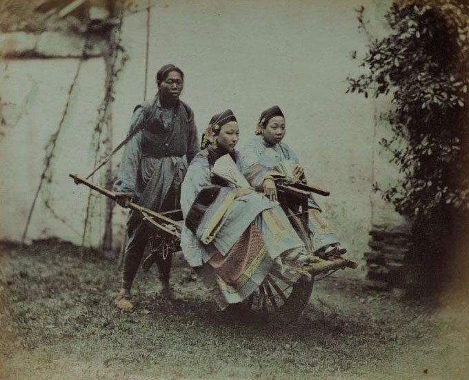 An image of a rickshaw driver transporting two wealthy women.