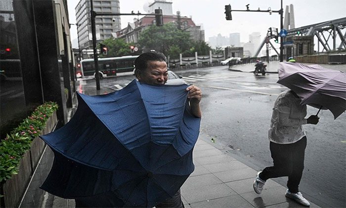 Pedestrians struggle during Typhoon Bebinca