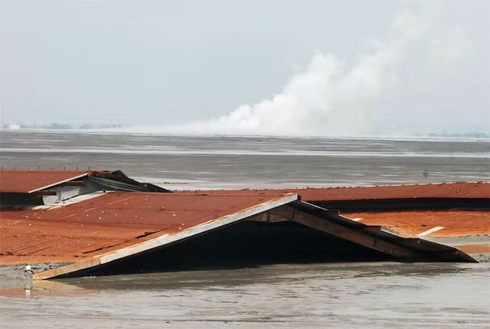 Homes submerged by the flow of mud, forcing 60,000 people to evacuate.