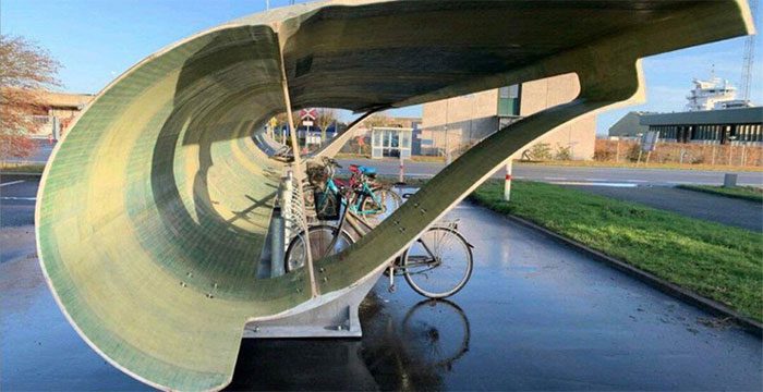 Decommissioned wind turbine blades transformed into bike shelters.