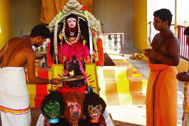 Priest performing a prayer ritual before the "Corona Devi" statue