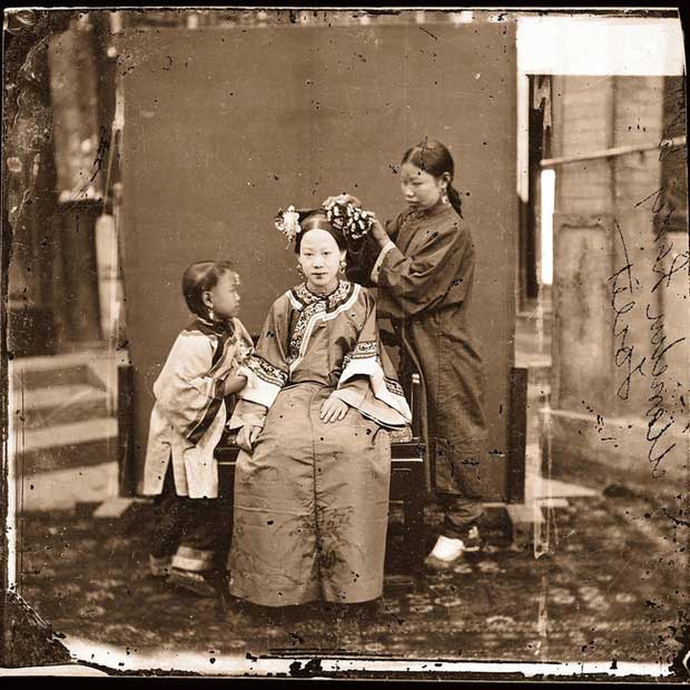 A noble Manchu woman getting her hair styled by a servant