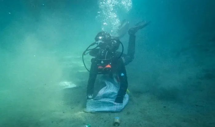 Divers collecting waste from the seabed at Naxos Island, Greece.