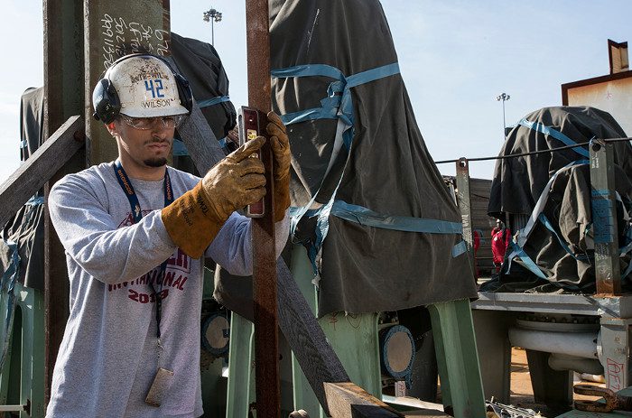 In the picture, pipe installer Trevin Wilson is working on the USS John F. Kennedy.