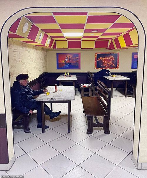 A contemplative guest enjoys beer in a shop.