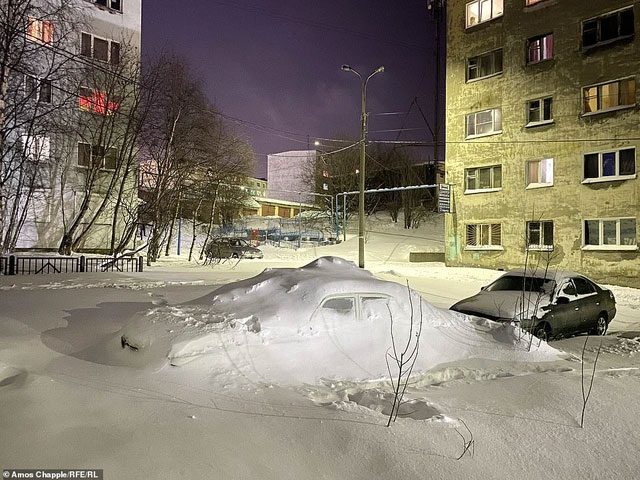 Heavy snowfall buries a car.