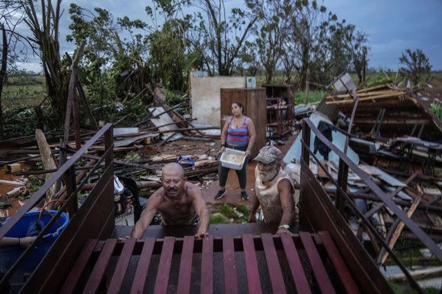 Residents recover belongings after Hurricane Rafael's destruction in Alquizar, Cuba in 2024.