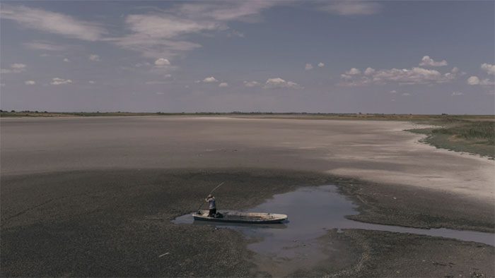 A worker collecting mud at Lake Rusanda, which has dried up for the first time in history