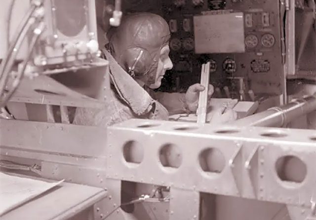 A technician using a slide rule to calculate an aircraft's fuel consumption