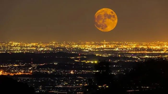 The Harvest Moon rises over Yokkaichi City, Japan in 2020.