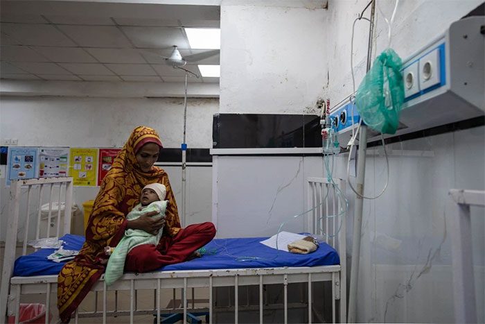 Sumaira, 25 years old, holding her child at Services Hospital in Lahore, Pakistan.