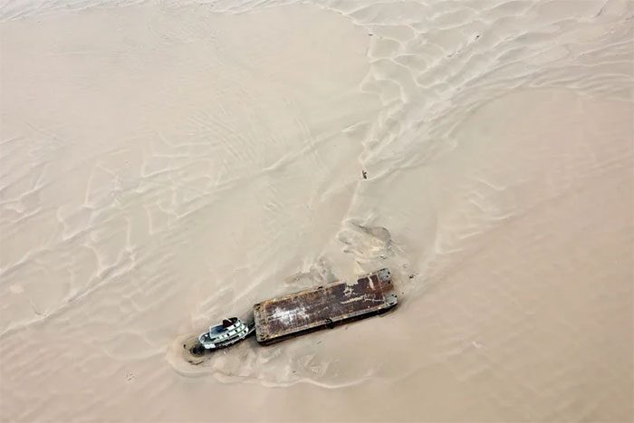 Barge carrying water stranded on the sandbank of the Solimoes River.