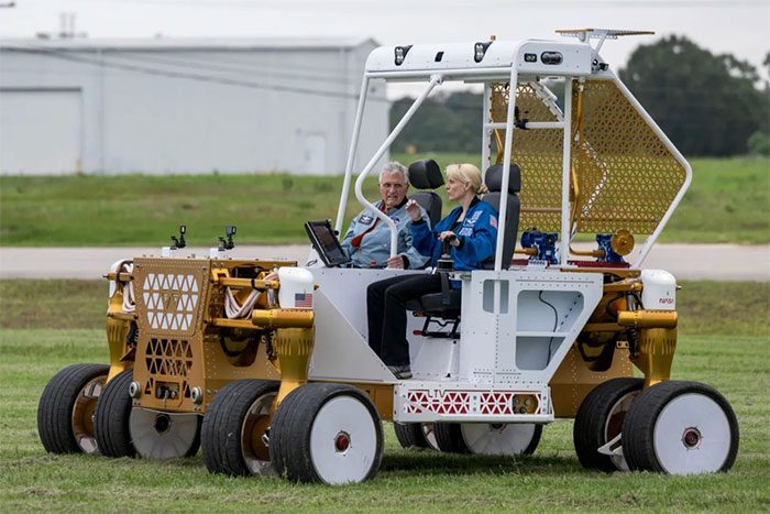 NASA astronaut with the prototype lunar rover at Johnson Space Center, USA