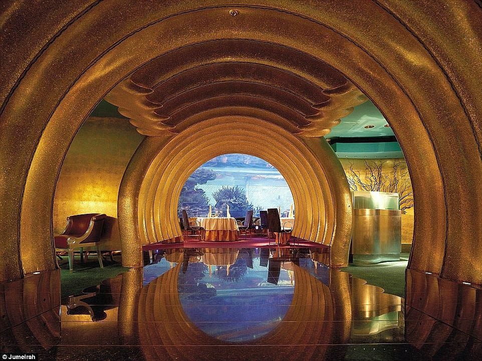 Burj Al Arab has 9 restaurants, including Al Maharba, where dining tables are arranged around an aquarium filled with colorful fish.