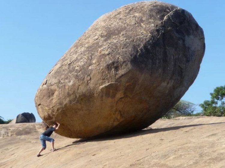 The giant rock remains immobile despite all efforts to move it.