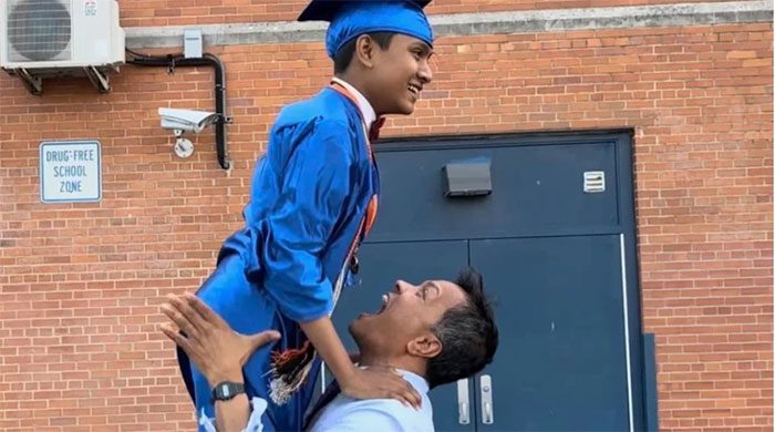 Suborno Isaac Bari celebrating with his father at his high school graduation